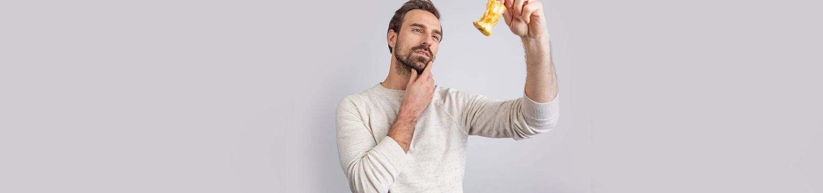 Fragen und Antworten Ein Mann hält einen Apfelrest empor und betrachtet ihn.