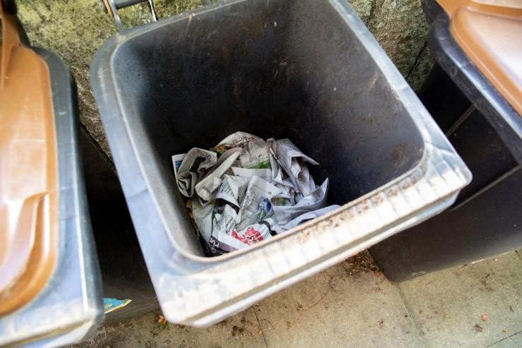 Keine Feuchtigkeit in der Biotonne Auf dem Boden einer Biotonne liegt zerknülltes Zeitungspapier