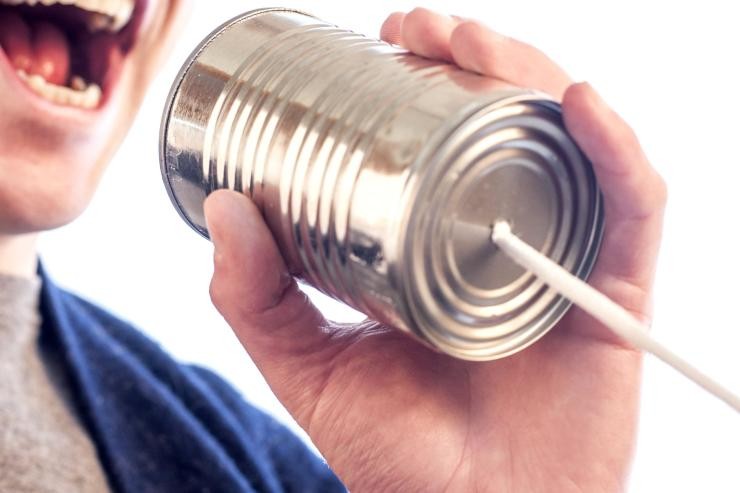 Ein Mann spricht in eine leere Konservendose