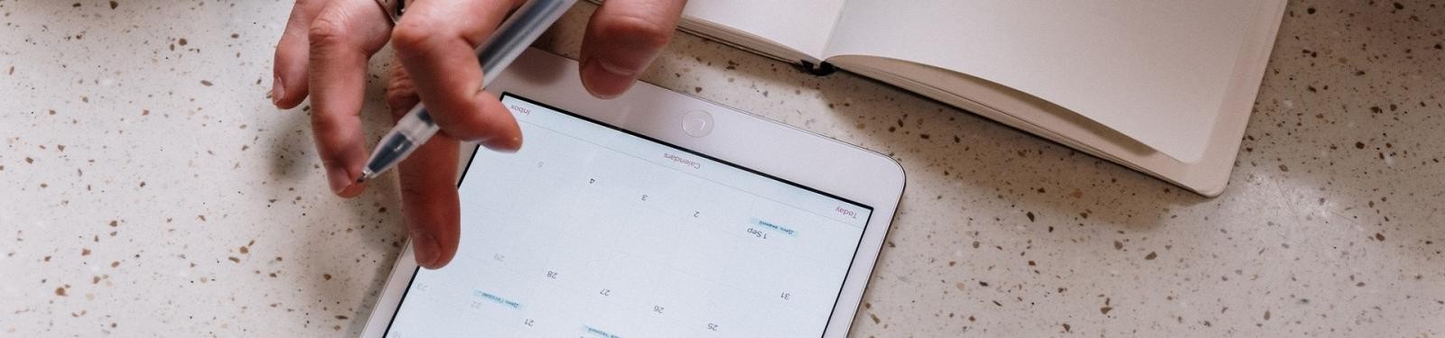 Abfallwirtschaft im Wandel Eine Hand tippt mit dem Finger auf dem Kalender auf einem Tablet