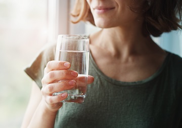 Trinkwasser aus der Leitung Eine Frau hält ein Glas mit Wasser