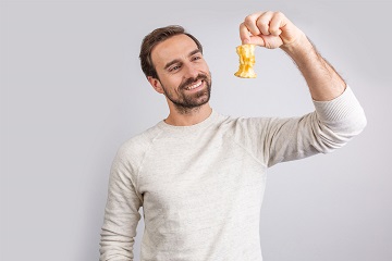 Ein Mann hält einen Apfelrest hoch und betrachtet ihn